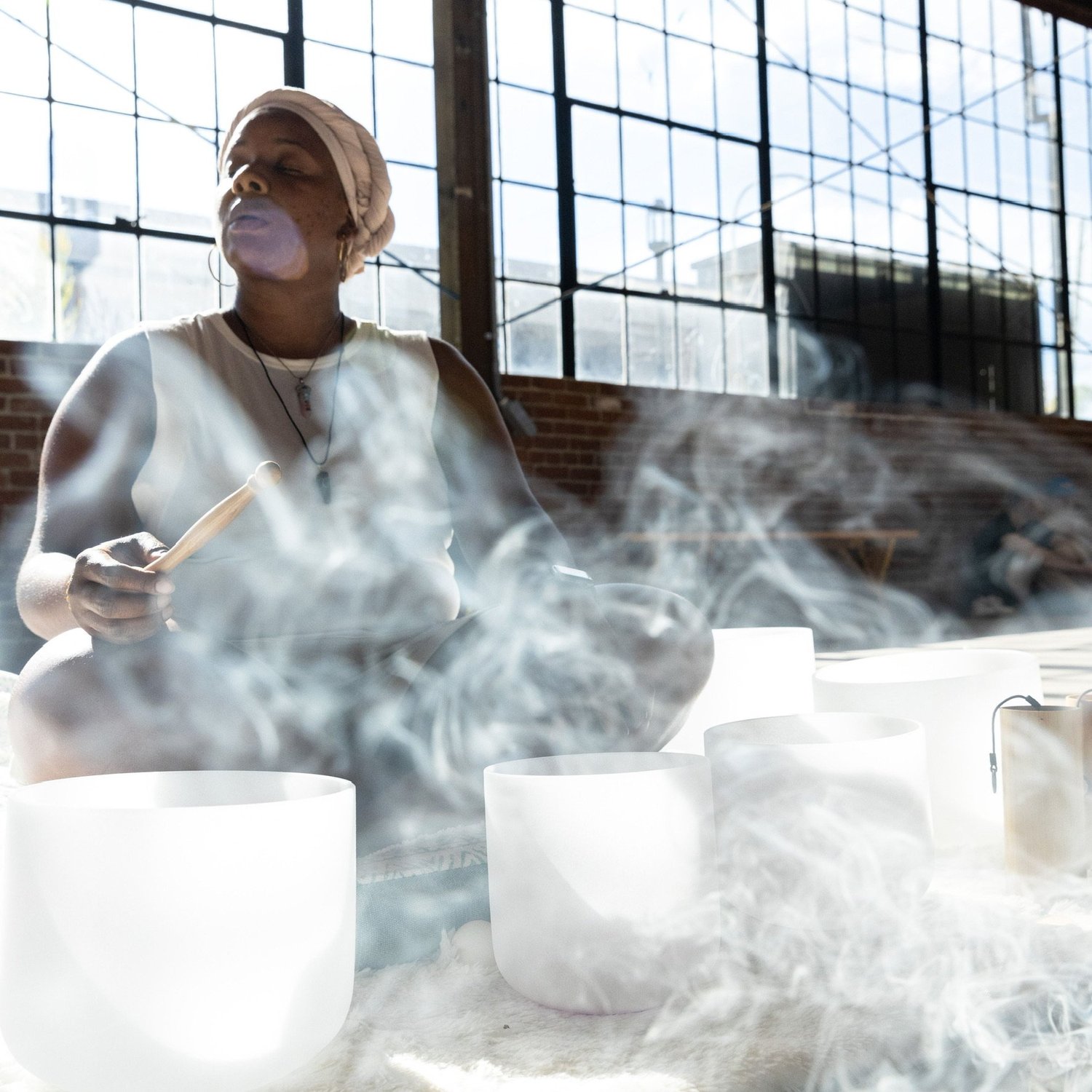 Jennifer Franklin-Moody playing crystal singing bowls in a daylit Los Angeles space