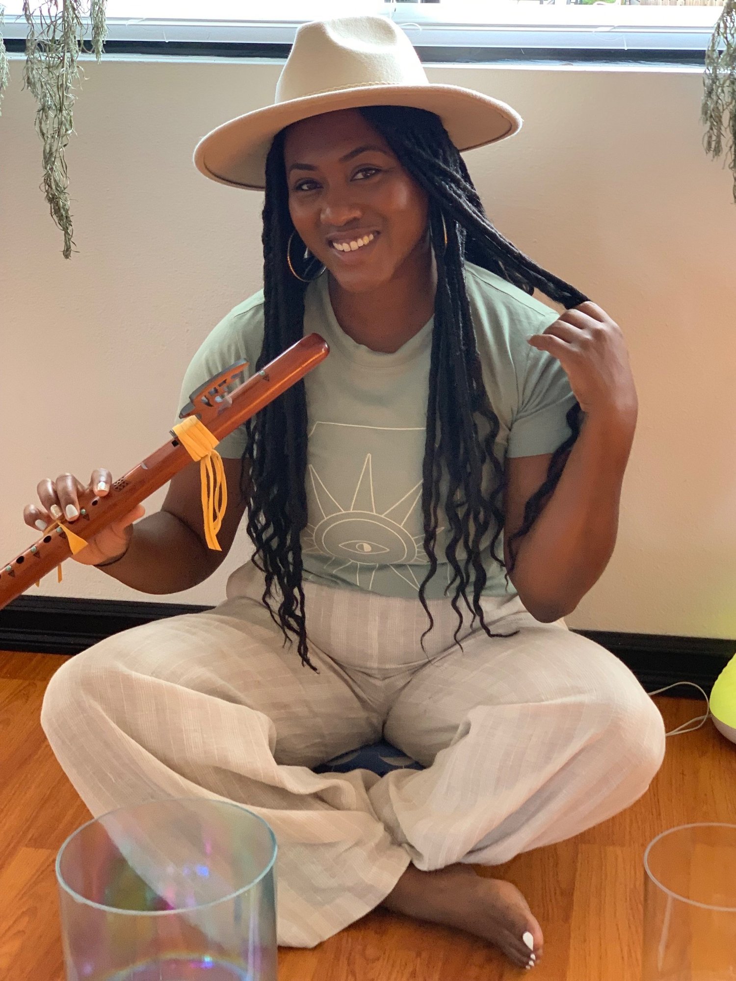 Jennifer Franklin-Moody seated with a flute and crystal singing bowls